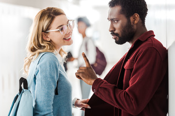 two multicultural students looking at each other in college