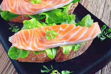 open sandwich with salmon and leaf vegetables