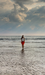 A charming girl walking in the sea. 