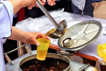 Social workers distribute compote to poor elderly people.