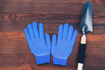 garden tools on a wooden background gloves and shovel