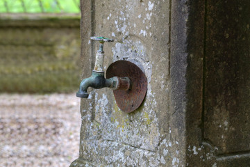 Old Rusty tap in the wall of the house