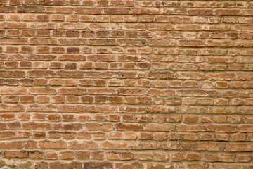 closeup of an old uneven brick wall background texture