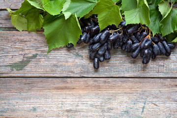  Cluster of Fanny Finger grapes on rustic wooden background. Close up, top view.