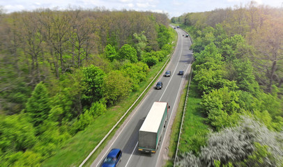 Obraz premium Highway intercity traffic with truck and cars. Transport logistic background.
