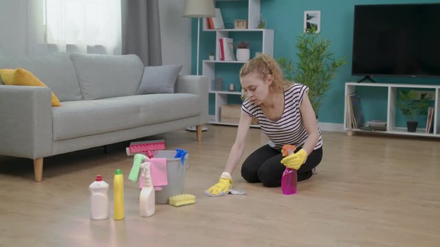 Tired woman wipes her forehead after cleaning her apartment