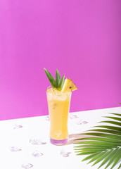 iced pineapple punch cocktail in glass on color background. summer drink.