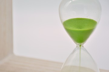 Reloj de arena verde sobre fondo blanco