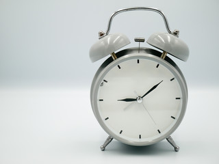 White retro with silver border alarm clock that represent number of analog on isolated white background