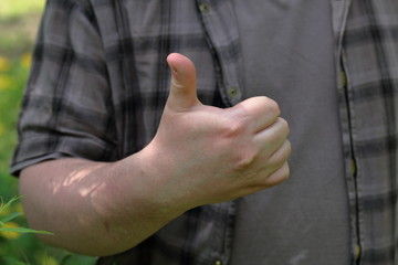 The young man raised up a thumb. Shows like. Close-up.