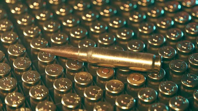 Rows of .50 BMG machine gun ammunition in plastic container.  One bullet on top.