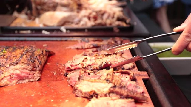 Slow motion serving delicious meat with tongs