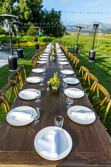 Table settings on a banquet table on Lawn