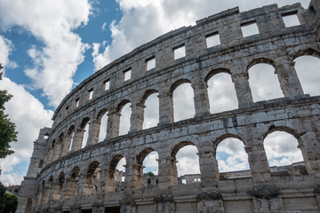 Fototapeta premium Coliseum arch with clouds in Pula, Croatia