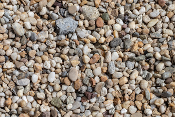 Gravel texture. Small stones, little rocks, pebbles in many shades of grey, white, brown, green and blue. Texture of little rocks