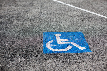 Handicapped parking spot, blue square on asphalt