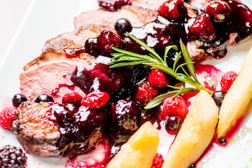 chicken and duck baked fillet on a plate with berry dressing