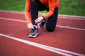 Cropped shot of female runner tying shoes