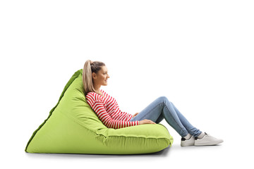 Young blond casual woman sitting on a green bean bag