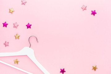 White hangers on pastel pink background