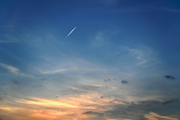 The plane flies obliquely up into the blue azure sky with blurred white clouds. It looks like the sea.