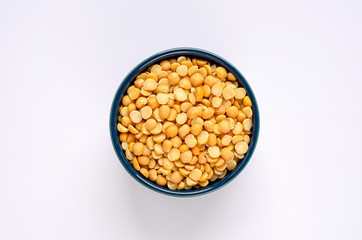 Bowl of yellow dried split peas on white background