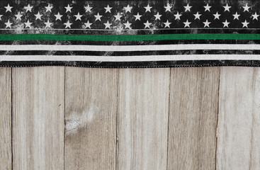 American thin green line flag over weathered wood background