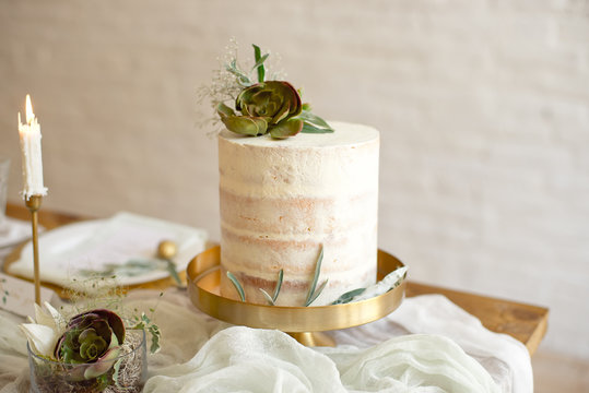 Elegant white wedding cake with flowers and succulents in boho style. Rustic Wedding Cake