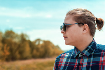 Guy in dark glasses on the background of nature.