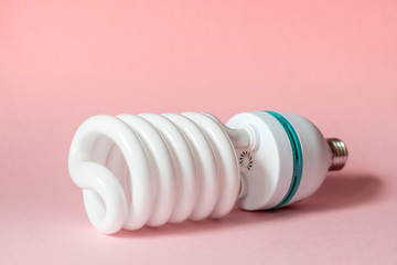 Close up view of white light bulb isolated on pink.