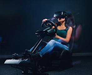 Obraz na płótnie Canvas Young woman wearing VR headset driving on car racing simulator cockpit with seat and wheel.