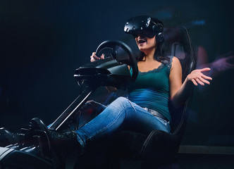 Woman wearing VR headset having fun while driving on car racing simulator cockpit with seat and...