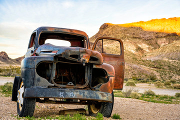 Rusty old car in the desert over sky