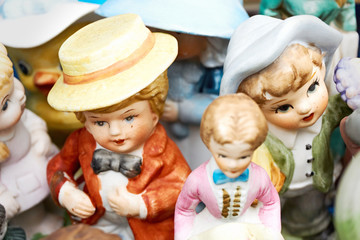 Closeup of old antique hand painted male and female human figures with hats at a flea market