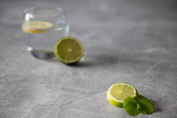 Pokorojona limonka w oddali szklanka z wodą