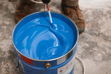 Bucket of blue paint mixing on motion