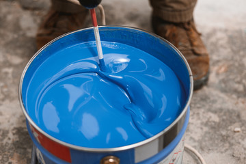 Bucket of blue paint mixing on motion