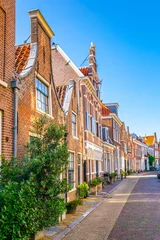 Deurstickers Classical red brick houses situated alongside Groot Heiligland street in Haarlem, Netherlands © dudlajzov