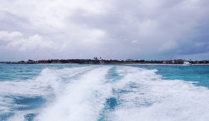 Distant storms/clouds over a small island during a boat-ride in the Ocean near Nassau in The Bahamas.