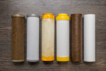 Old and new filter cartridges for water. New and used blocks filters for cleaning water in...