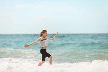 Young girl running through the waves at the beach