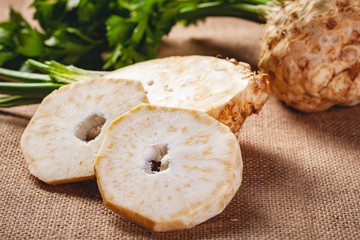 Celery root with leaves on sackcloth background. Close up