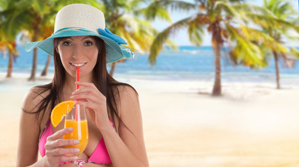 Woman holding a fruit cocktail on a tropical beach. Summer concept.