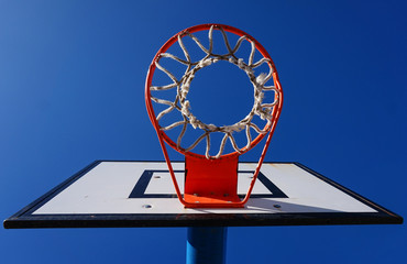 Tablero de baloncesto con fondo de cielo azul desde abajo