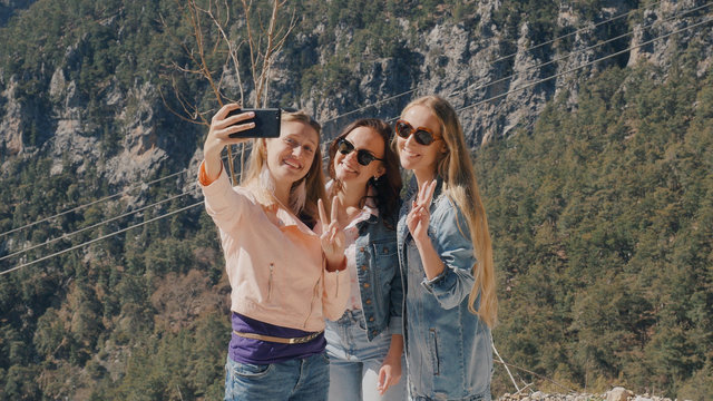 Three young women taking selfie with mobile phone
