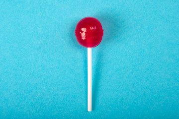 Red lolipop on blue background. Top view, sweet candies concept