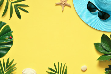 Tropical Background. Palm Trees Branches with starfish and seashell on yellow background. Travel. Copy space.