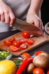 young woman in a gray apron cherry tomatoes