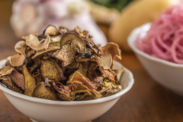 Dried mushrooms sour cabbage garlic and potatoes on wooden table
