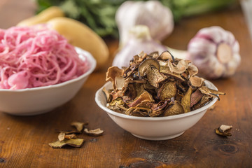 Dried mushrooms sour cabbage garlic and potatoes on wooden table